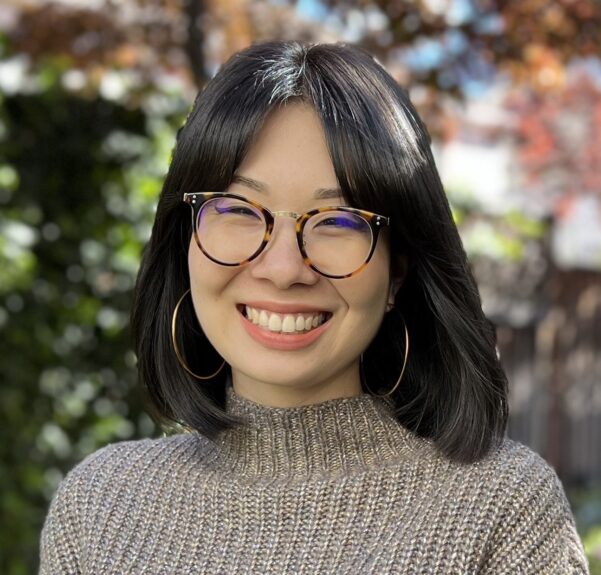 Professional headshot of Haruna Matsusaka, a colleague of Kristy Shanks, smiling confidently at the camera against a soft, blurred background. Haruna is wearing a professional looking turtleneck sweater, and the lighting highlights her friendly and approachable demeanor. width=